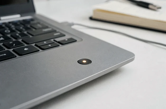 Gros plan sur le bouton power clignotant d'un PC portable Lenovo avec voyant LED ambré